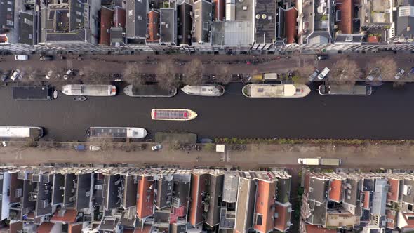 Canal Boat Tour in Amsterdam Amongst Riverside Houses Bird's Eye View