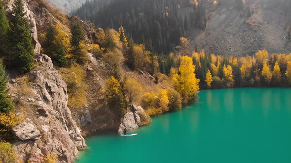 Man Is Paddling on Sup Board in the Mountain Lake