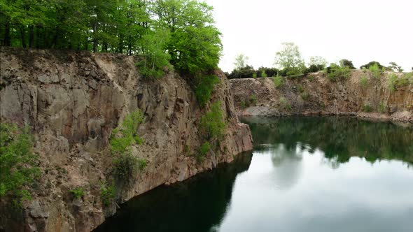 Fly along cliffs over quarry pond