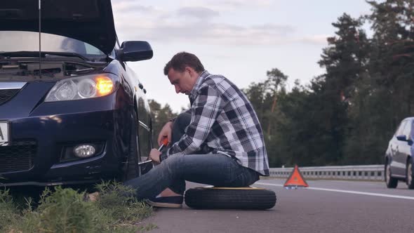 Guy Changing a Tire Outdoors