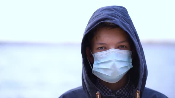 Boy Medical Mask on His Face During Quarantine Stands on Beach During the Second Wave Quarantine