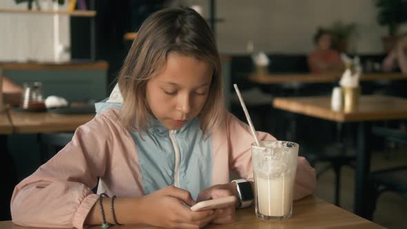 Beautiful Girl in Sitting in Cafe Counter and Drinking Milkshake While Taking Cute Photos