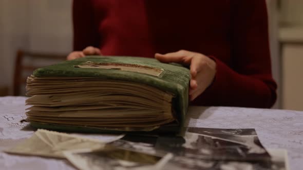 Hand Old Woman Is Looking at Old Photo Album at Home