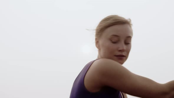 Young female dancer performs smoothly hand movements while rehearsing her performance background