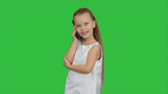 Cute little girl talking on the cell phone on a Green Screen