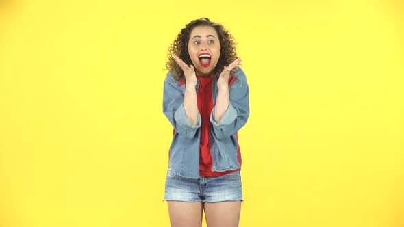 Very Surprised Girl with Shocked Wow Face Expression on Yellow Background at Studio