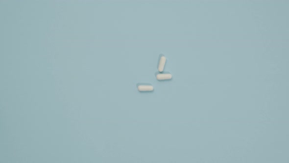 female hand folds oval white pills