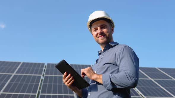 Engineer Solar Photovoltaic Panels Station Checks with Tablet Computer