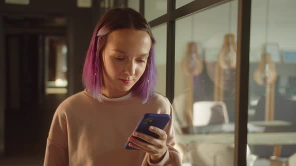 A Young Girlstudent Stands Near the Window Meets Her Friend and Then Reads Posts on the Internet