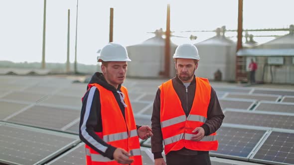 Two engineers in protective uniform on solar farm