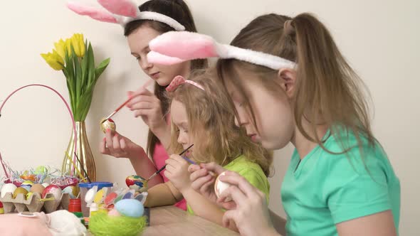 Side View of Little Girls Painting Chicken Eggs with Paint