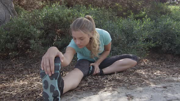 A young woman runner stretching before her run.