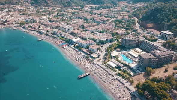 Aerial Top View of Beach with Sunshade and People Swimming at Beautiful Blue Color Sea