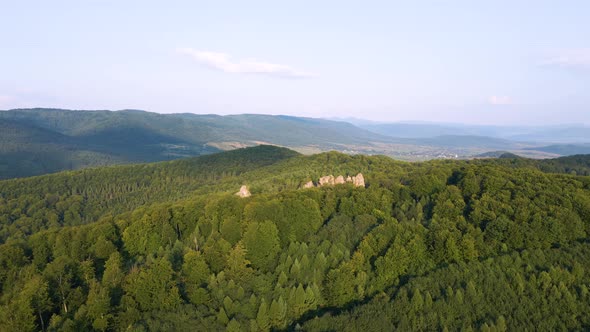 Aerial View of Bright Landscape with Green Forest Trees and Big Rocky Boulders Between Dense Woods