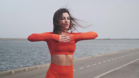 Athletic fitness woman exercising outdoors. A girl in sportswear goes in for sports and makes turns