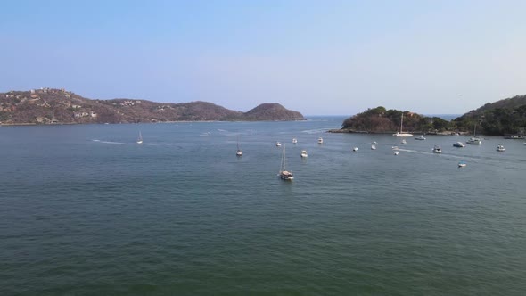 Drone flying over the ocean of Ixtapa located in the state of Guerrero, Mexico during a sunny day.