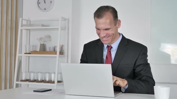 Middle Aged Businessman Celebrating Success of Project