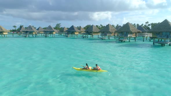 Aerial drone view of a man and woman couple on a tandem sea kayak in Bora Bora tropical island