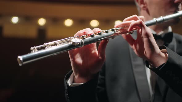 Flutist is Playing in Symphonic Orchestra or Brass Band Closeup View of Flute in Male Hands