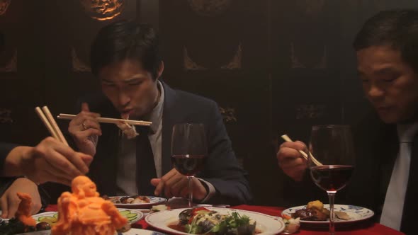 Businessmen eating in Chinese restaurant