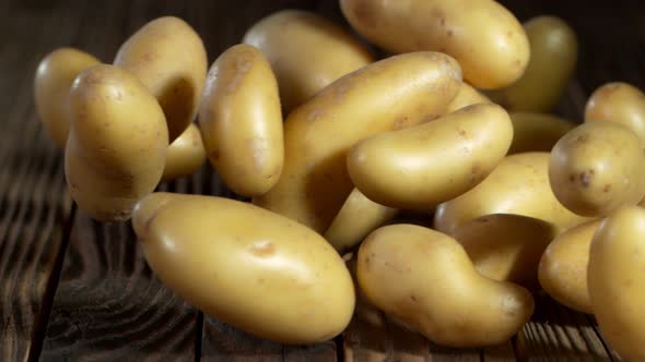 Super Slow Motion Shot of Potatoes Rolling on Old Wooden Table at 1000Fps.