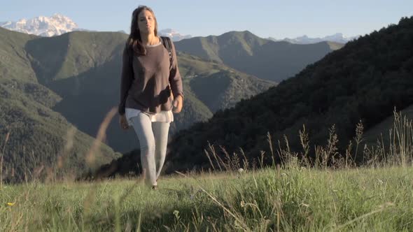 Front View of Young Woman Hiking Toward Camera in Mountain Outdoor Nature Scenery During Sunny