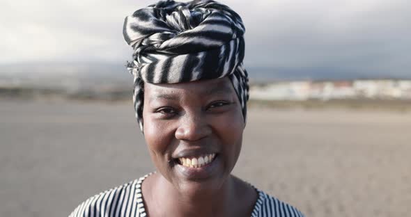 Close up of african woman wearing turban and smiling in camera