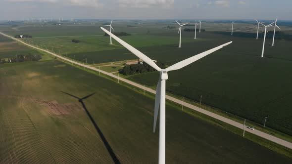 Aerial video orbiting around a wind turbine on a sunny summer day in Iowa.