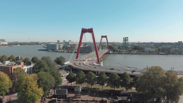Aerial footage of the Willemsbrug Bridge spanning across a water channel in Rotterdam, Netherlands.