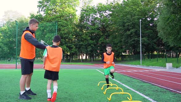 Football Trainer Giving High Five to His Pupils After they Finished to do Running Exercises