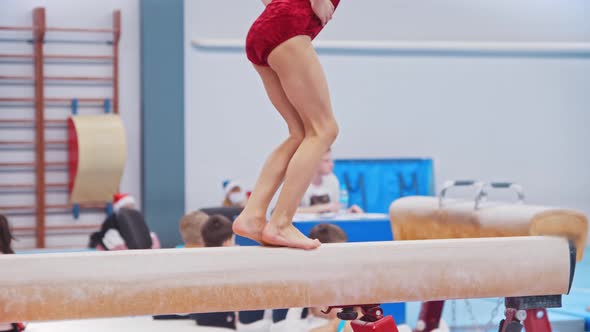 A Little Gymnastics Girl Jumping on the Bar