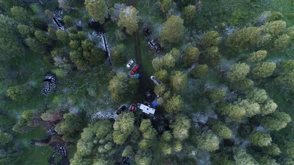Aerial view looking at campsite deep in a pine tree forest in Idaho