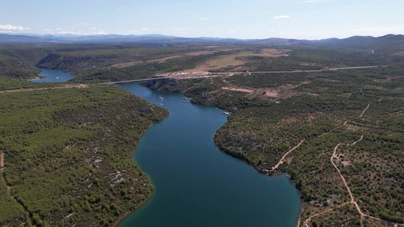 Flying over Krka river, autostrada and arch bridge at summer in Croatia, Europe