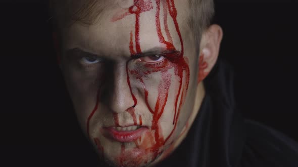 Halloween Man Portrait. Guy with Dripping Blood on His Face. Scary Makeup