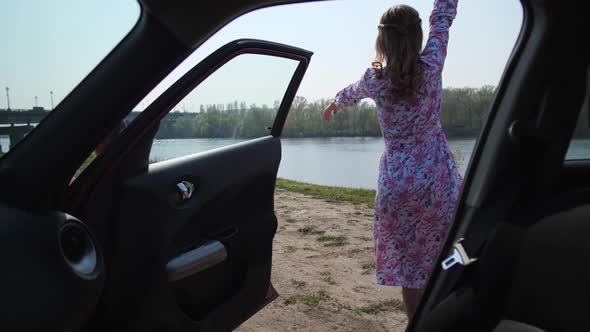 The Girl Gets Out of the Car Leaving the Door Open and Enjoying Nature Spinning Raises Her Hands Up