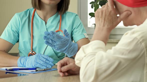 Cancer Female Patient in a Scarf After Chemotherapy Communicates with an Oncologist