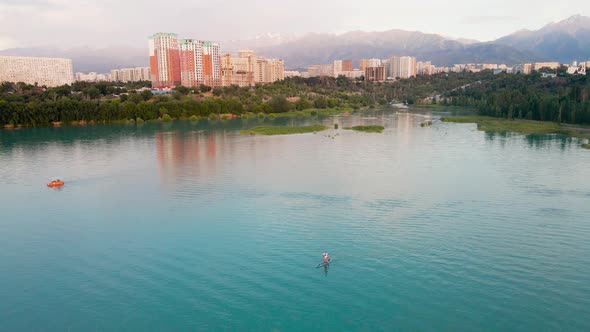 Man Ride on SUP Board in the Mountain Lake