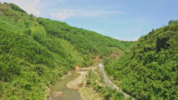 Drone Flies Above Green River Against Highlands Blue Sky