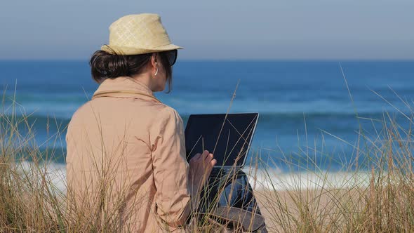 Blogger Working in Her Notebook on Beach