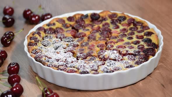 Cherry Clafoutis with powdered sugar in baking dishes