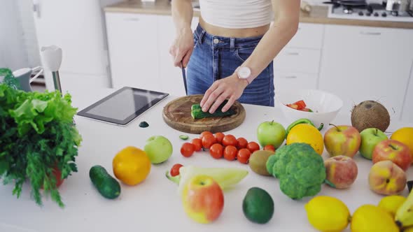 Delicious fruit and vegetables on a table and woman cooking.