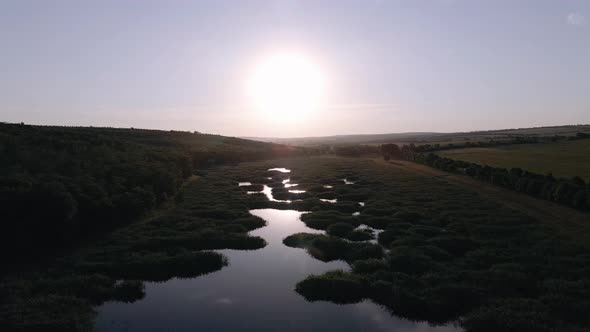 Video with Drone Over a River in the Forest at Sunset