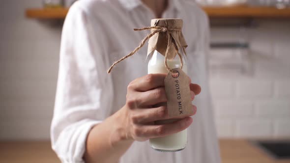 Potato Milk The Hand Of A Young Girl Holds A Bottle Of Milk Beautifully Packaged From Raw Potato