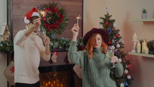 Smiling lover, couple dancing with sparkler fire laughing and dancing to celebrate Christmas