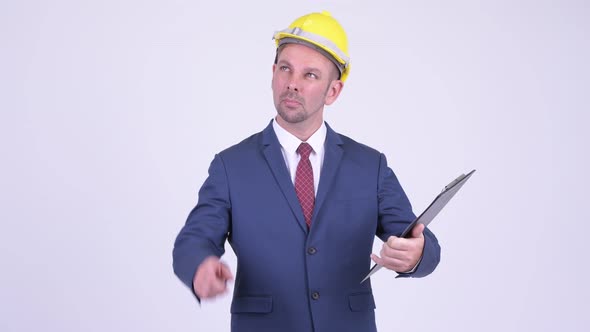 Happy Businessman As Engineer Holding Clipboard and Pointing Finger