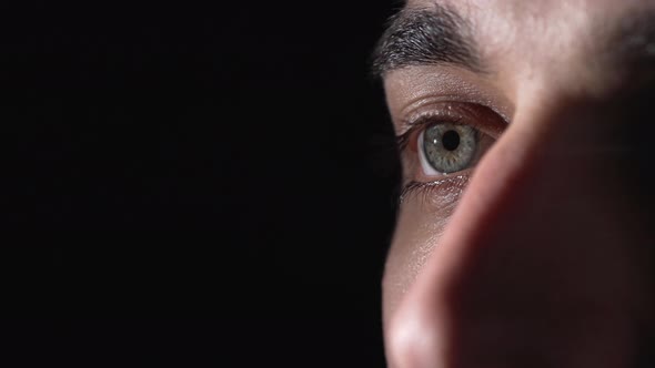 Portrait Extreme Closeup of European Man 20s Moving Green Eyes and Blinking While Looking Aside in