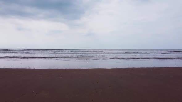 Drone shot of North sea beach. Empty beach with waves crashing.