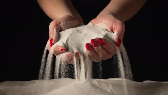 Woman Picks Up Clean White Sand in Her Palms and Sprinkles It Through Her Fingers