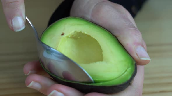 Young woman taking a green avocado