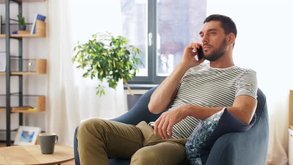 Happy Man Calling on Smartphone at Home